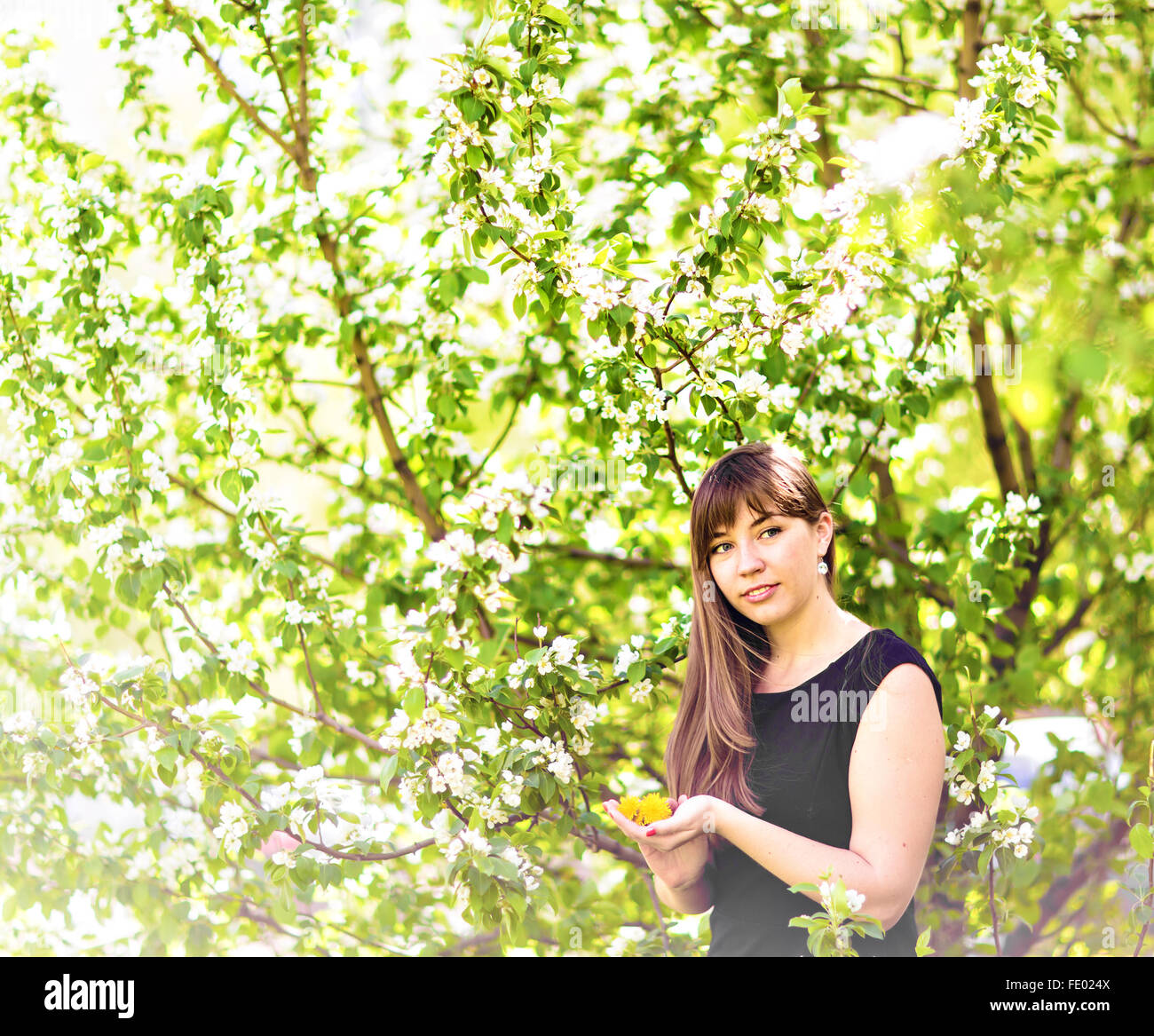 Portrait of beautiful girl with bouquet of yellow dandelions outdoor in ...