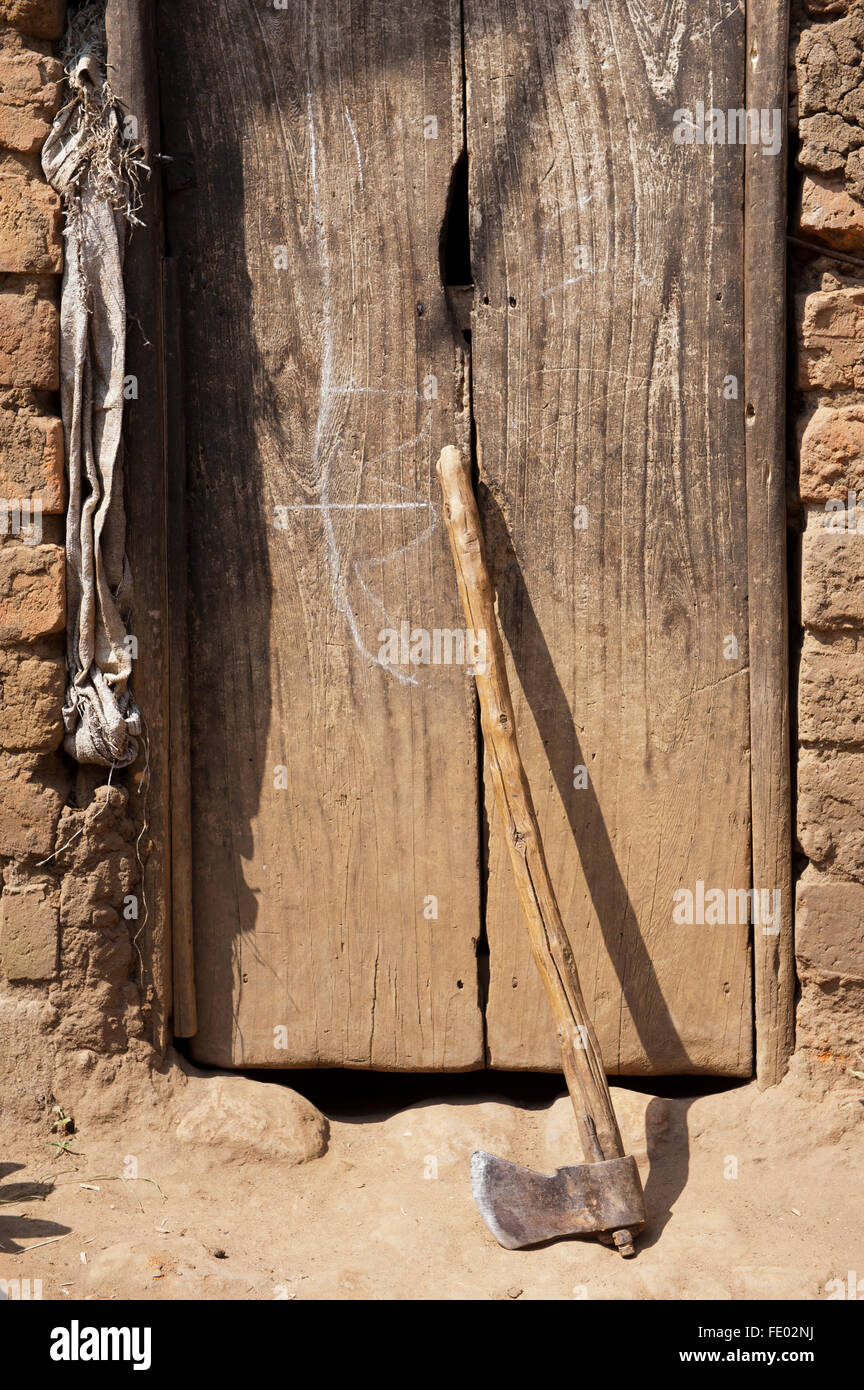 Axe with homemade handle leaning against house door, Uganda Stock Photo Alamy