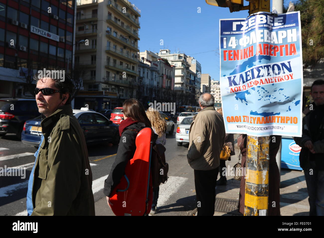 Thessaloniki, Greece. 3rd February 2016. Pedestrians wait at traffic lights near a poster announcing a general strike and a rally. Greek public and private sector unions called for a nationwide general on Thursday to protest againts government's planned pension reforms that are part of the country's 3rd international bailout. Public transport is excepted to be severely disrupted, and taxi drivers are expected to join the action. Credit:  Orhan Tsolak/Alamy Live News Stock Photo
