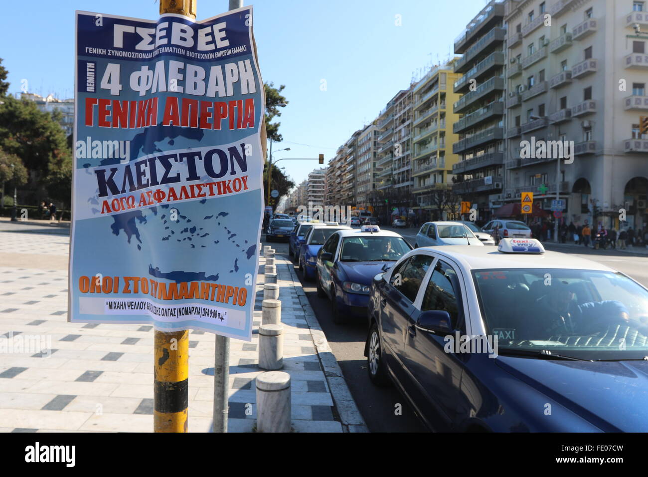Thessaloniki, Greece. 3rd February 2016. Taxi drivers wait for custormers next to a poster announcing a general strike and a rally. Greek public and private sector unions called for a nationwide general on Thursday to protest againts government's planned pension reforms that are part of the country's 3rd international bailout. Public transport is excepted to be severely disrupted, and taxi drivers are expected to join the action. Credit:  Orhan Tsolak/Alamy Live News Stock Photo