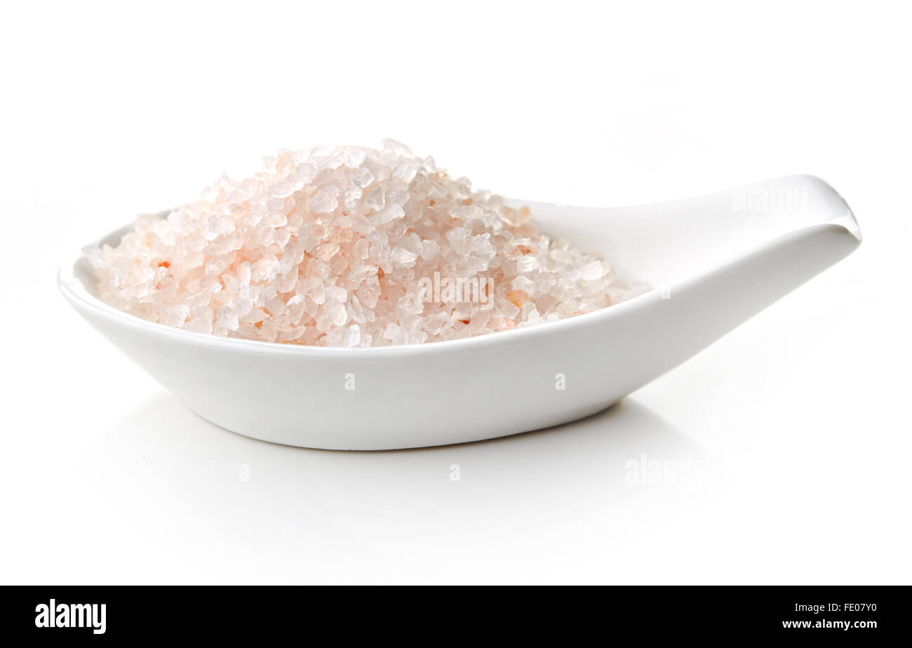 Himalayan salt in white porcelain spoon on white background Stock Photo