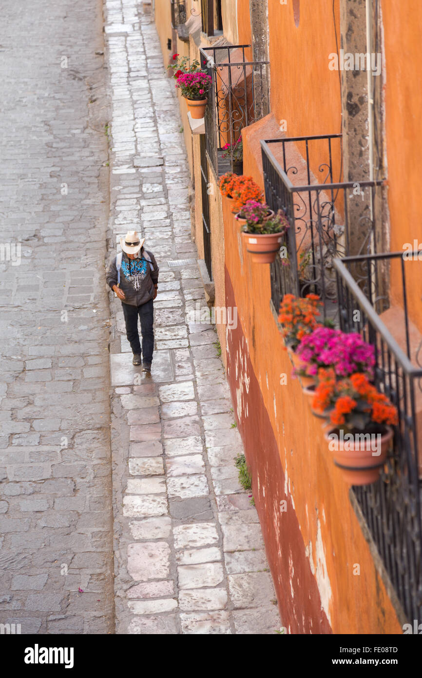 A cowboy walks down Canal Street in the historic center of San Miguel de  Allende, Mexico Stock Photo - Alamy