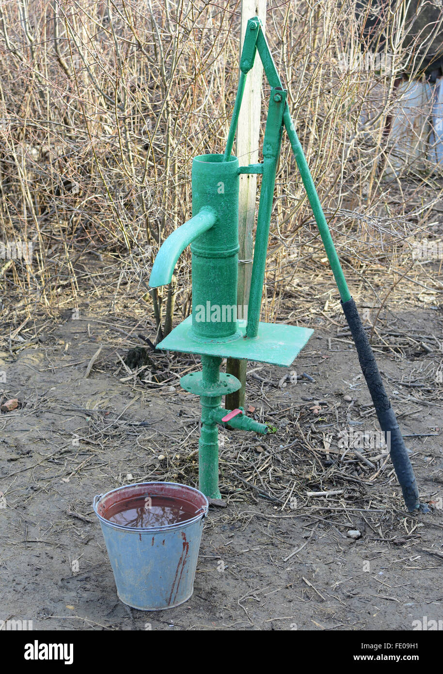 Hand pump leading to an artesian well. Pumping water for watering the
