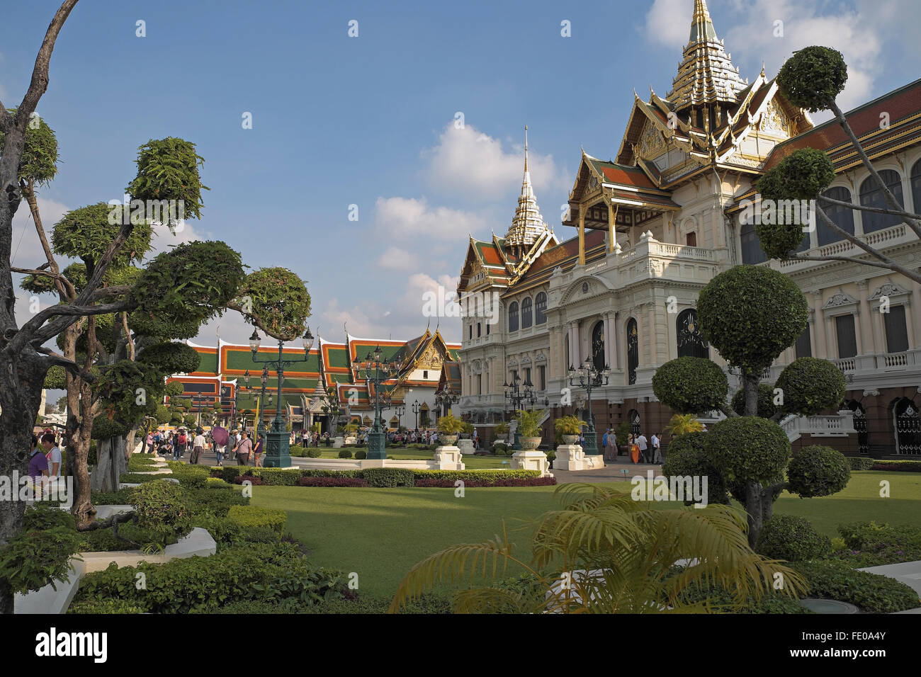 Pollarded trees and lawns, with Chakri Maha Prasat Hall, The Grand Palace, Bangkok, Thailand, Asia. Stock Photo