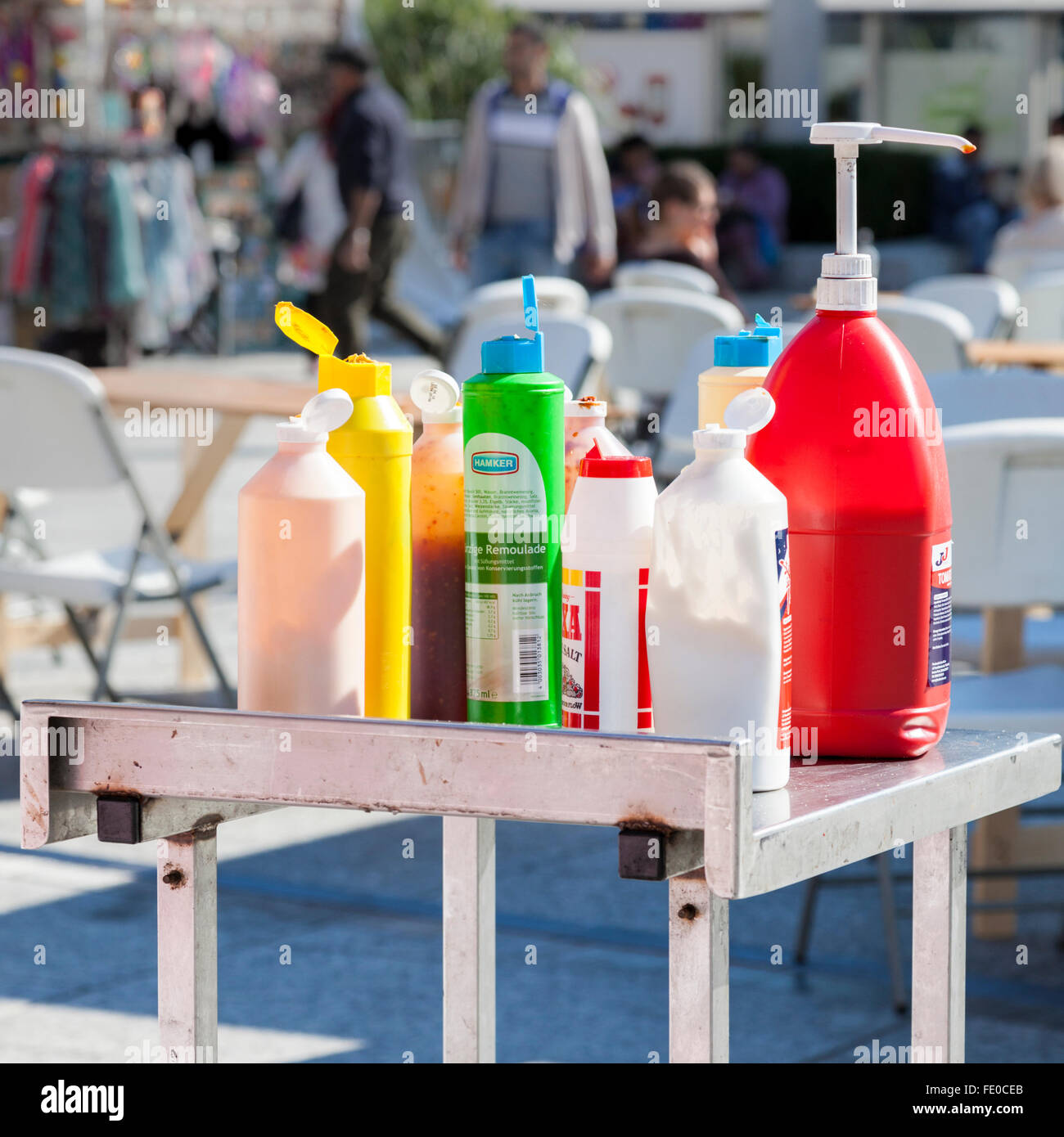 Plastic bottles of salt, tomato ketchup, mustard, mayonnaise and other sauces and toppings. Food stall at an outside event, Nottingham, England, UK Stock Photo