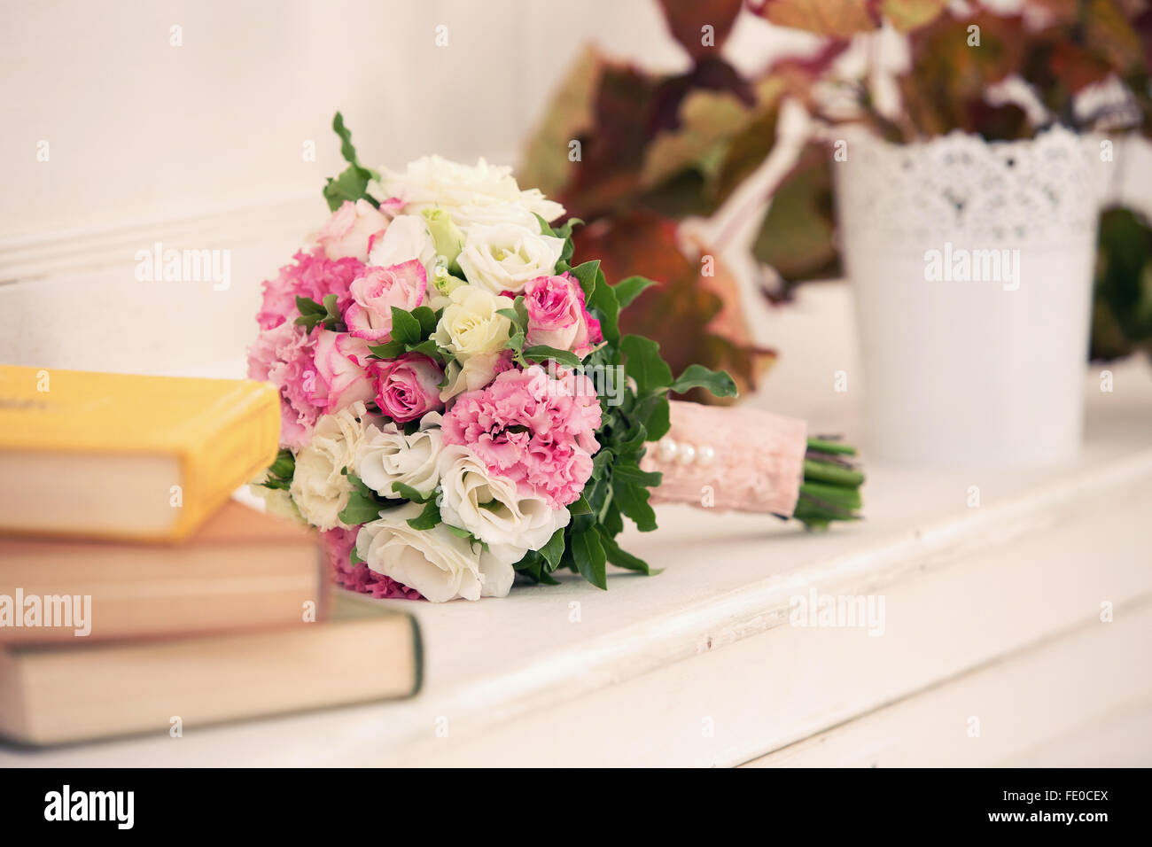 bridal bouquet from roses of pink color and a pile of books Stock Photo ...