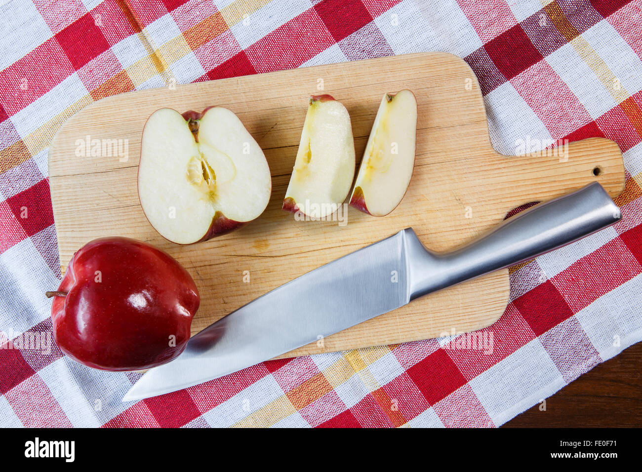 Red apple on cutting board with stainless steel knife Stock Photo