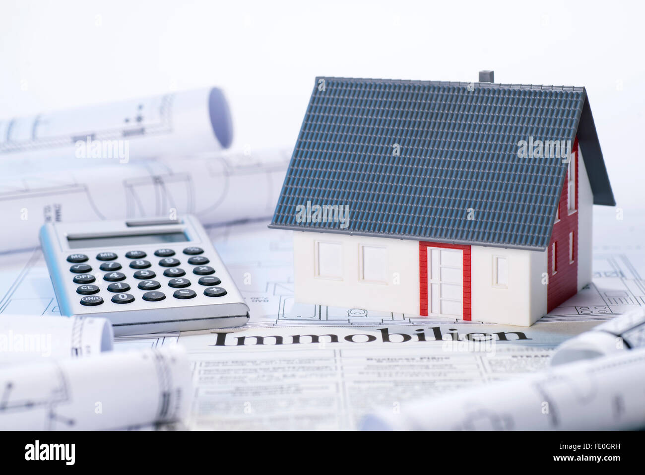 House with blueprints, real estate ads and calculator Stock Photo Alamy