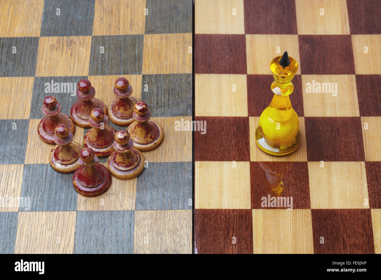 Luxurious chess king opposing shabby pawns in concept of social inequality. Stock Photo