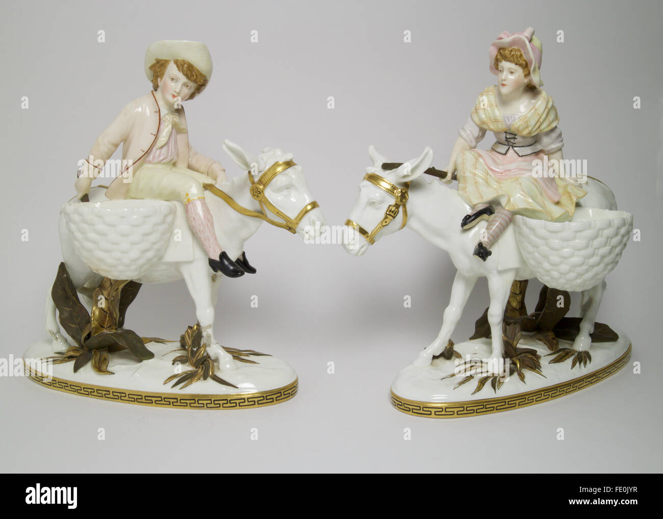 Pair of large antique Moore Bros porcelain figures consisting of a young couple riding donkeys. The figures measures approximate Stock Photo
