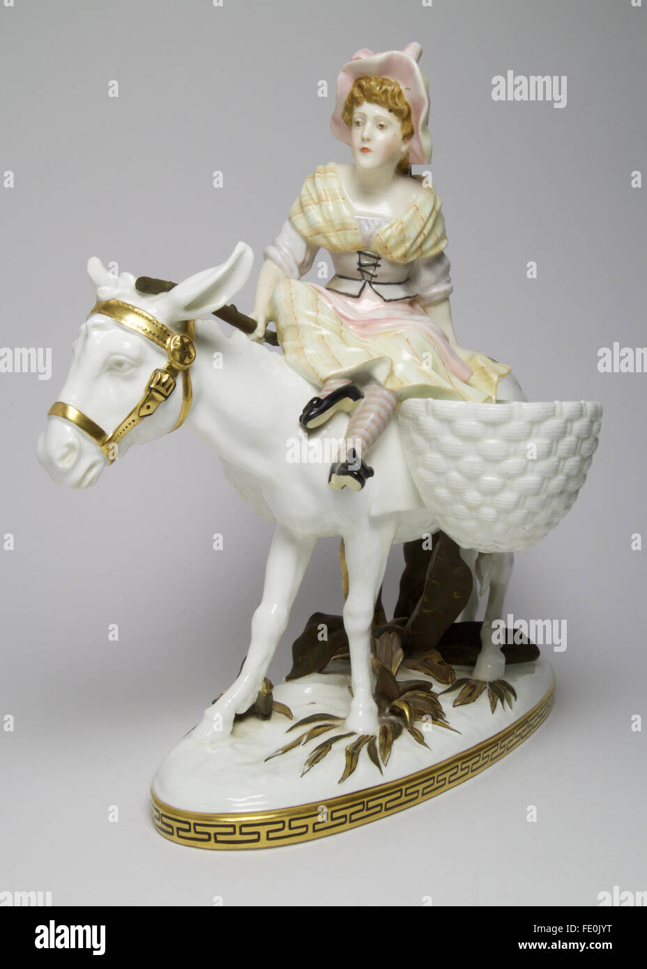 large antique Moore Bros porcelain figure of a young girl riding a donkey. . The figures measures approximate Stock Photo