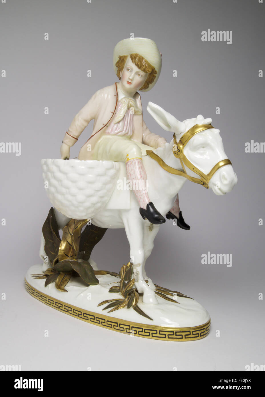 large antique Moore Bros porcelain figure of a young boy riding a donkey. Stock Photo