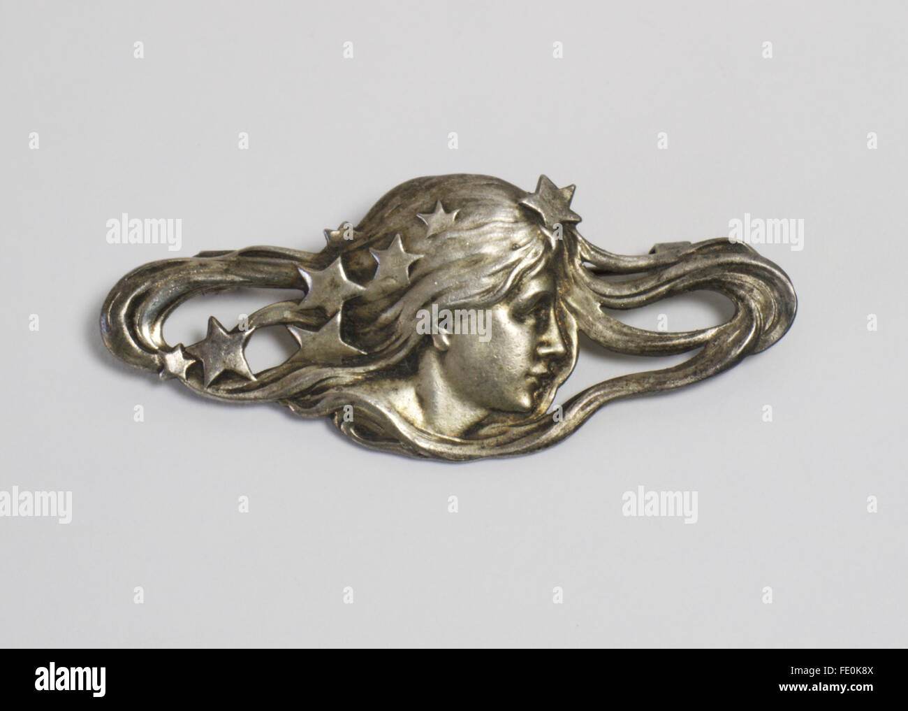 Vintage reproduction Art Nouveau silver plated brooch in the form of a maiden with stars in her sinuous hair. The brooch was ori Stock Photo