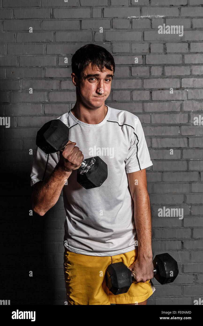 Nerd with dumbbells Stock Photo