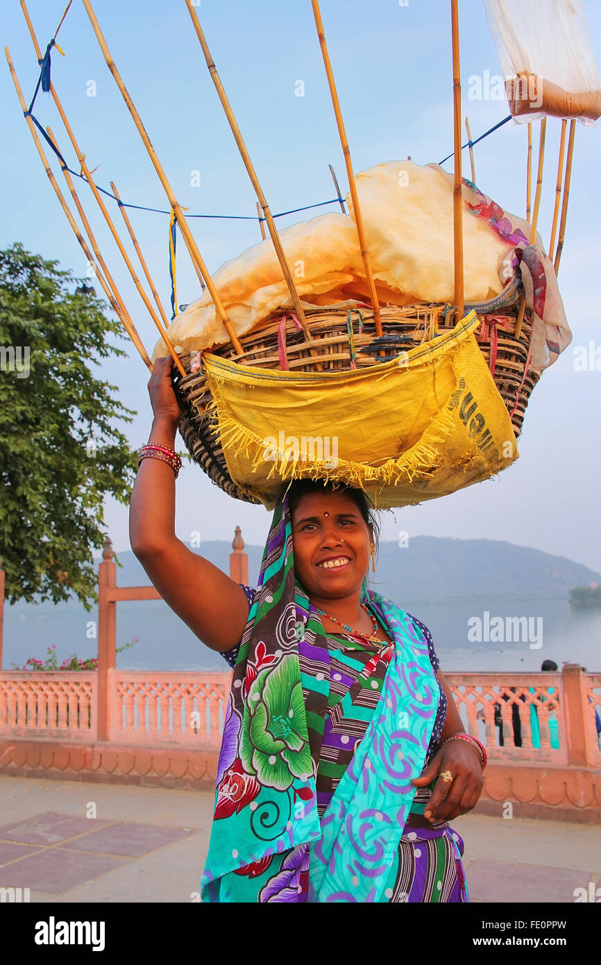 Indian woman with basket on her head selling snacks by Man Sagar Lake in Jaipur, Rajasthan, India. Stock Photo