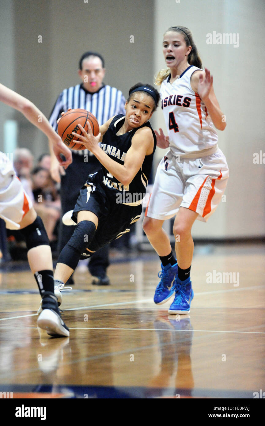 Player driving in the lane and past a defender while attempting to score during a high school basketball game. USA. Stock Photo