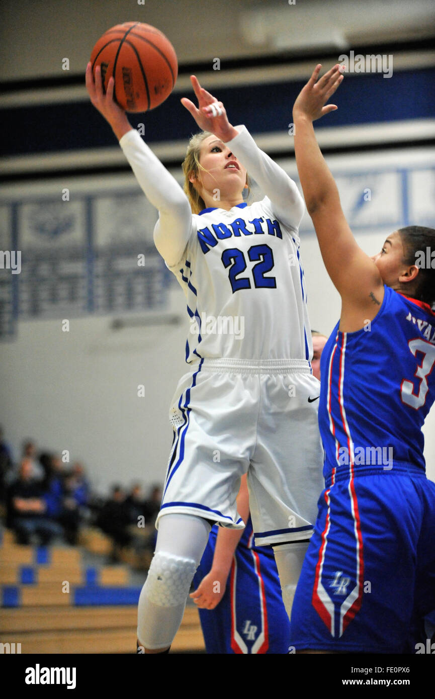 Off a pivot,a high school forward pours in a field goal over a defender  during a high school basketball game. USA Stock Photo - Alamy