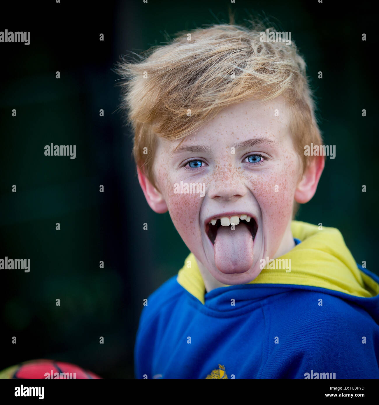 Young boy sticking his tongue out when he realizes he is having his photo taken Stock Photo