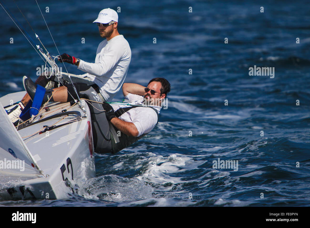 Sailors hiking on International Star Class racing yacht during the