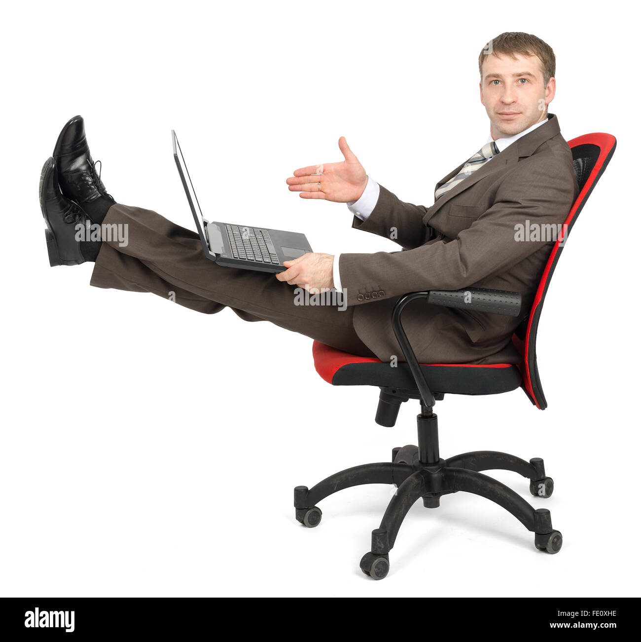 Businessman sitting on chair with laptop Stock Photo - Alamy