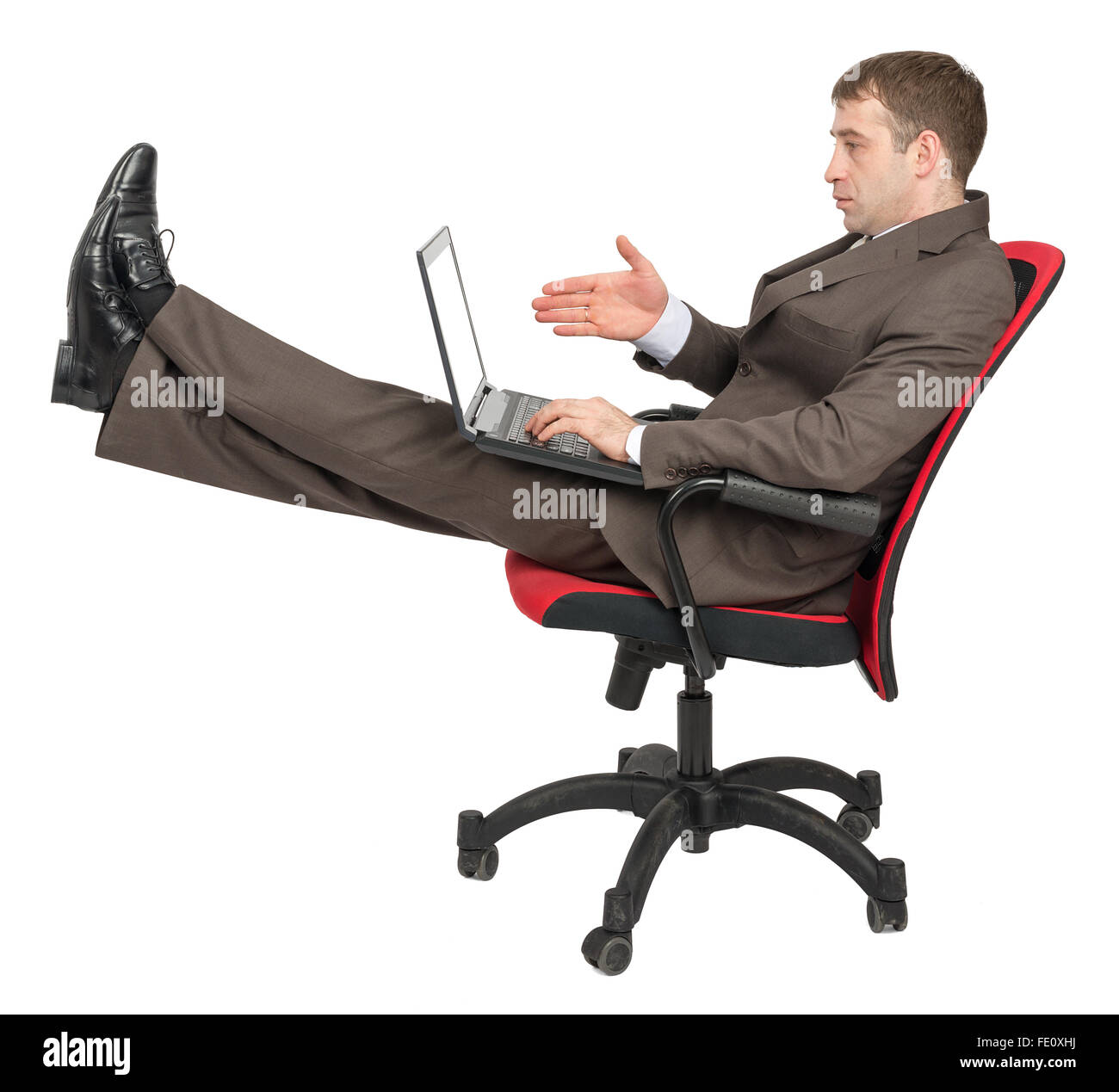 Businessman sitting on chair with laptop Stock Photo - Alamy