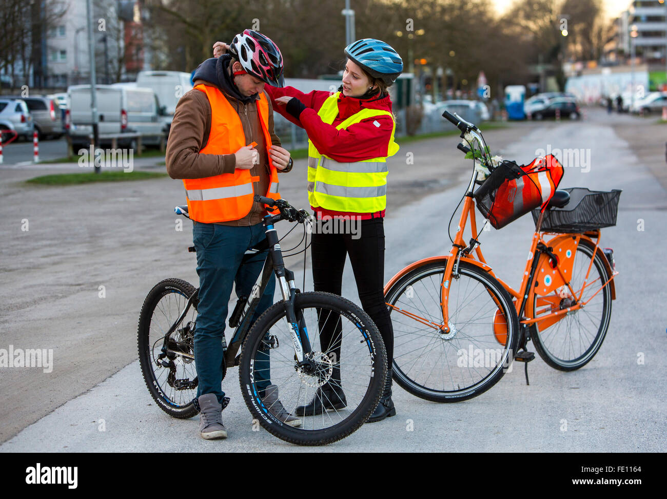 Cyclist put on safety clothing, bike helmet and reflecting vest for bike  safety, good visibility at night in traffic Stock Photo - Alamy