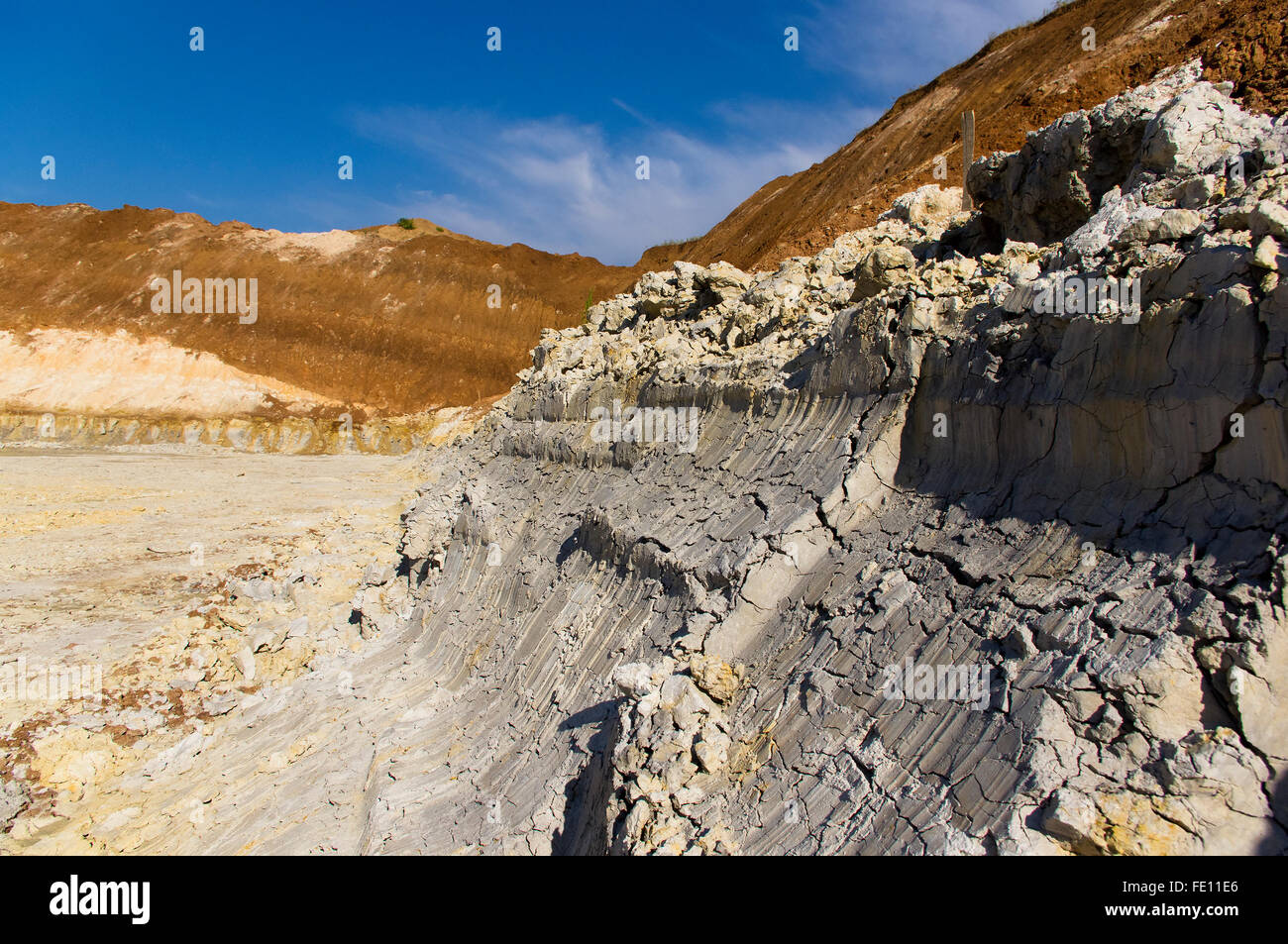 clay quarry with traces of the excavator bucket on blue sky background Stock Photo