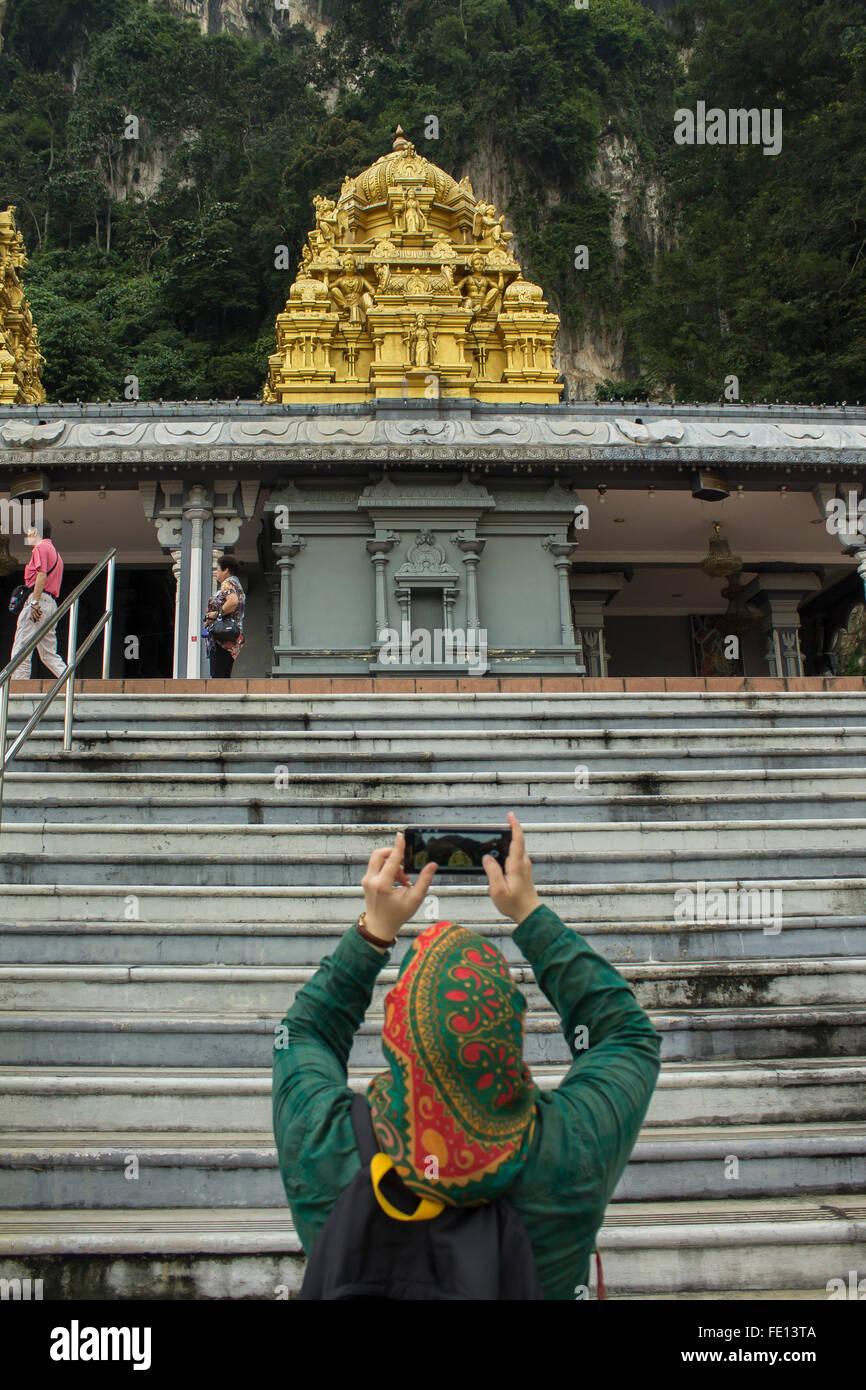 A Muslim tourist with Hijab photographing in Batu Caves, Kuala Lumpur. Malaysia Stock Photo