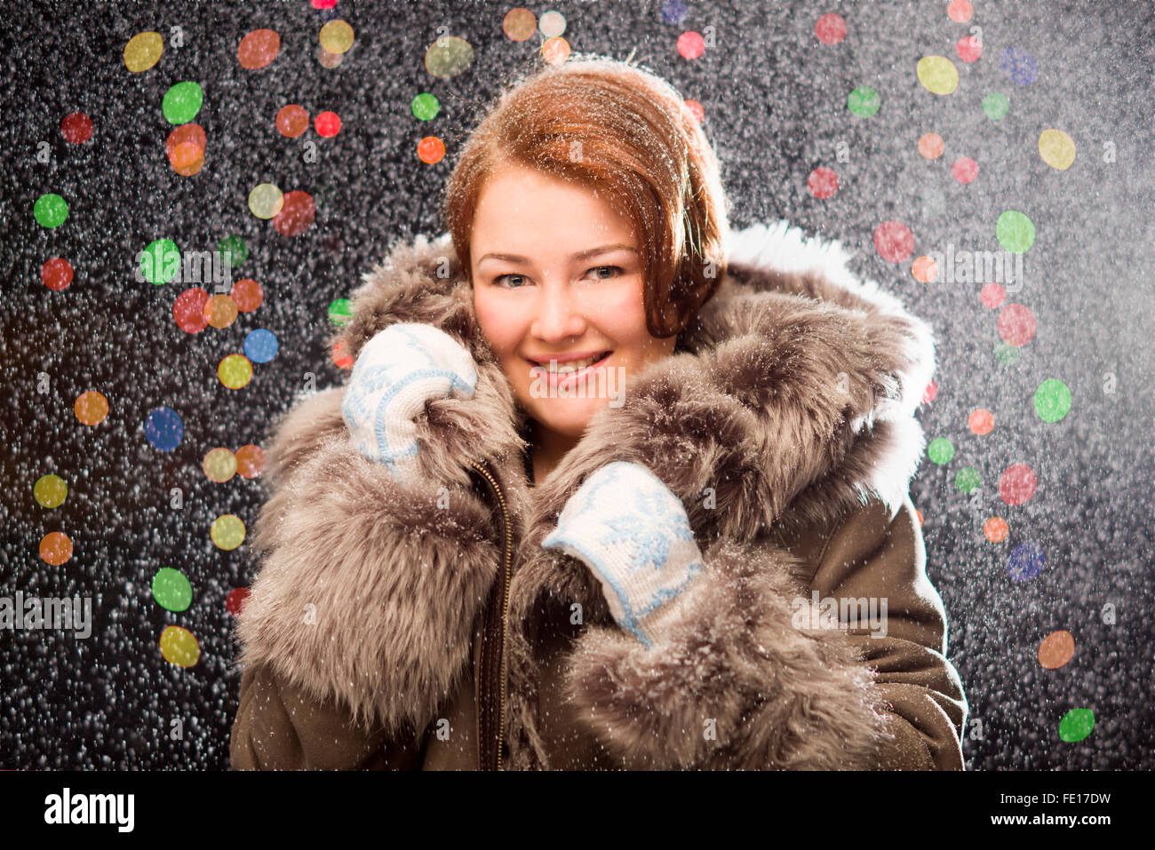 Ginger girl in fur coat wearing mittens with snow Stock Photo - Alamy