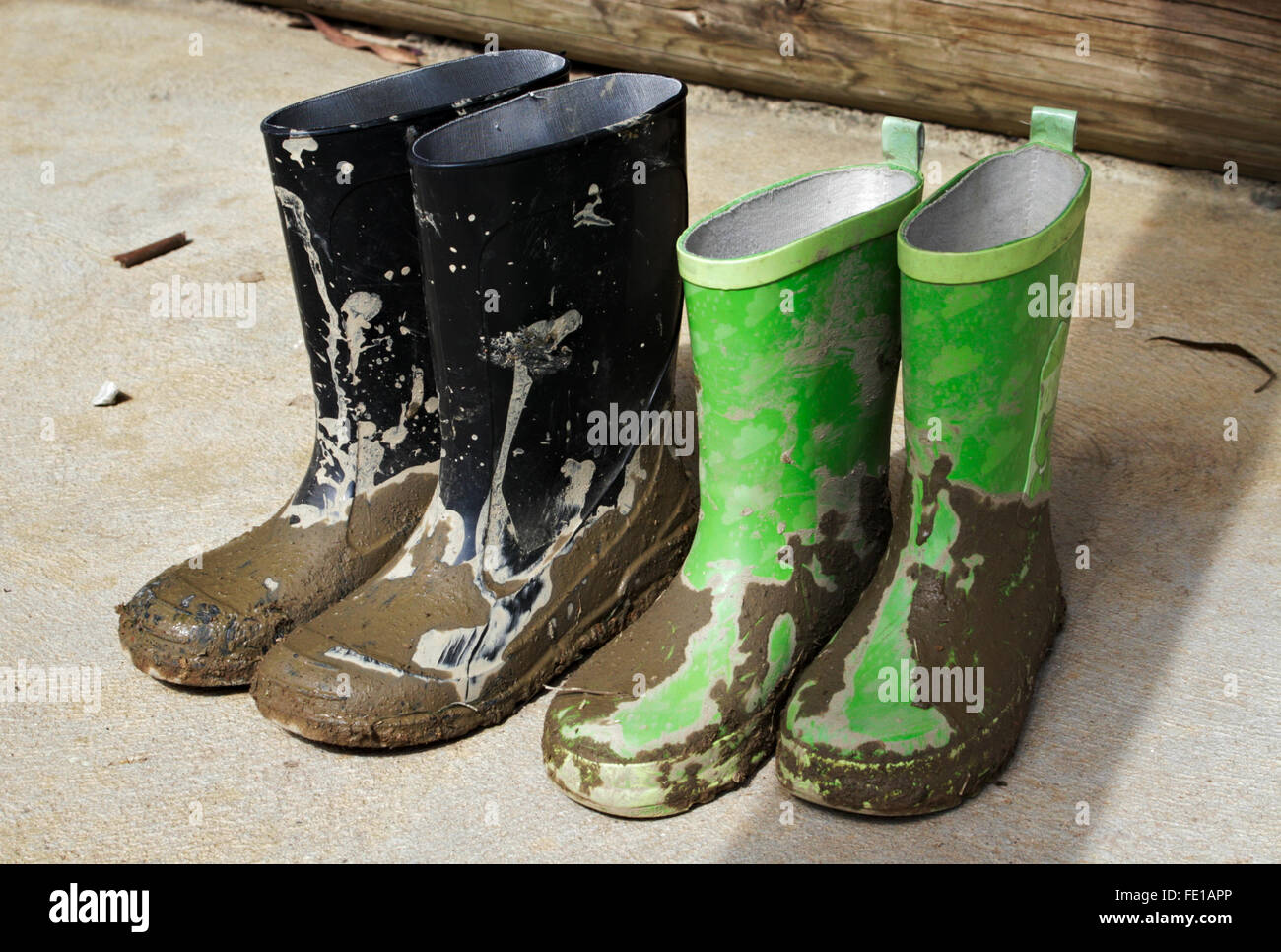 Children's muddy gumboots/galoshes drying in the sun. Stock Photo