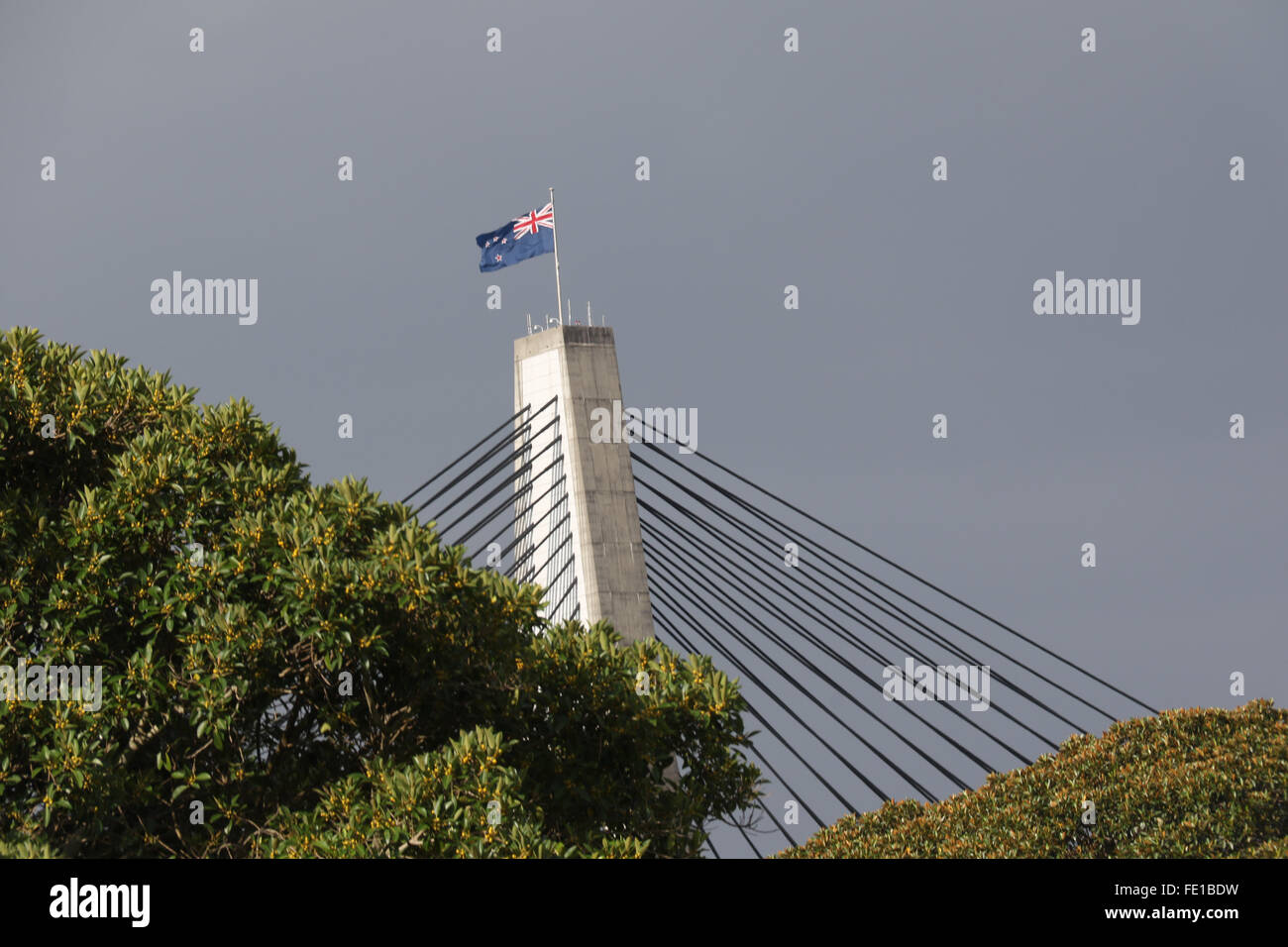The Australian flag flies over the ANZAC Bridge viewed from Bicentennial Park, Glebe – Sydney, Australia Stock Photo