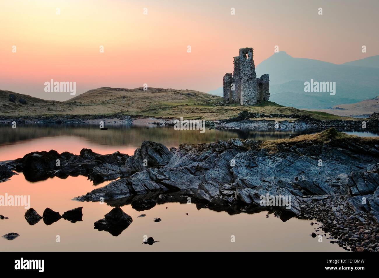 Ardvreck Castle on the shore of Loch Assynt, north west Highlands, Scotland, dates from 15th C. Quinag mountain behind Stock Photo