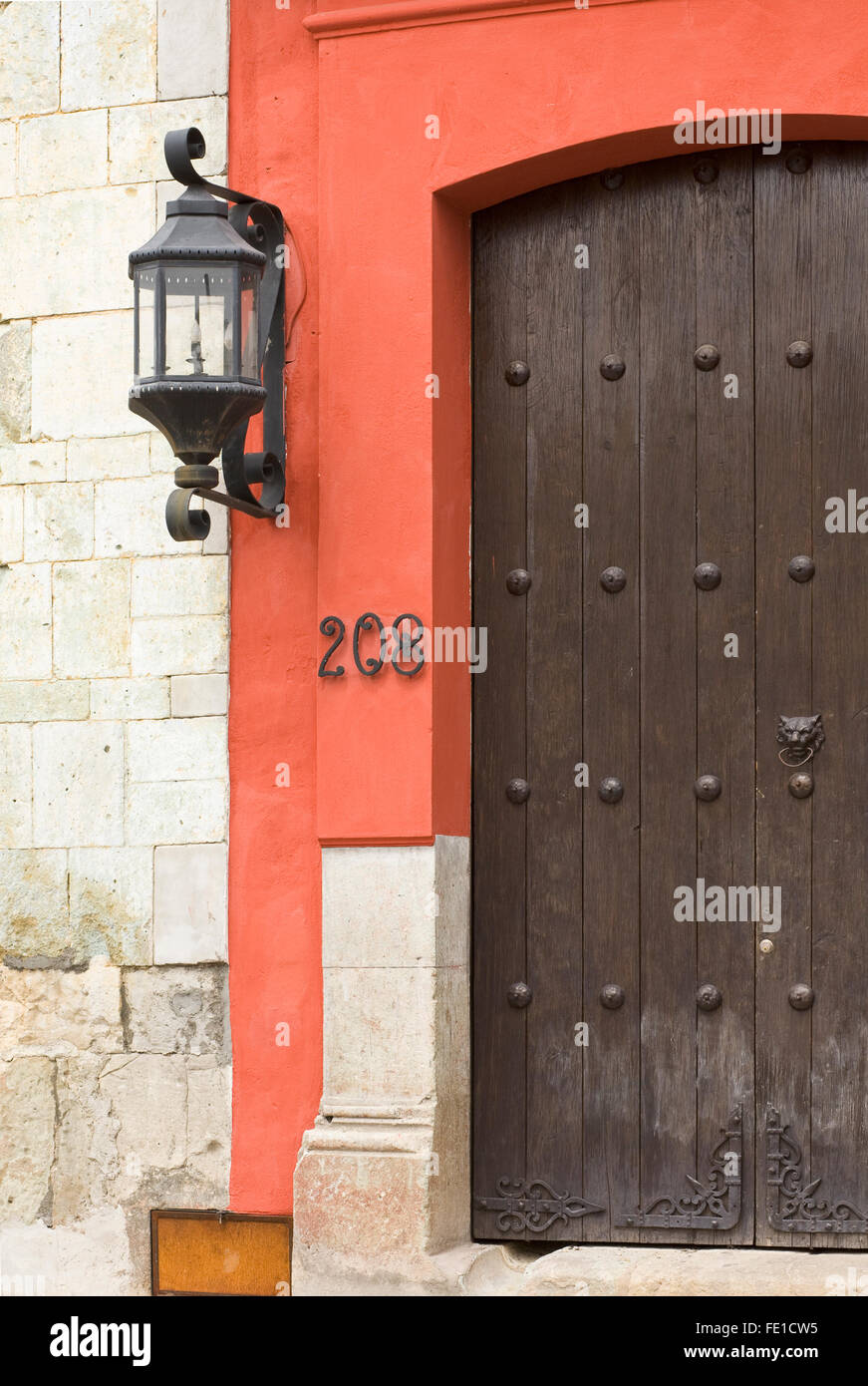 Wooden garage door, wrought iron lamp and house numbers of a typical home entryway, Oaxaca City, Oaxaca, Mexico Stock Photo