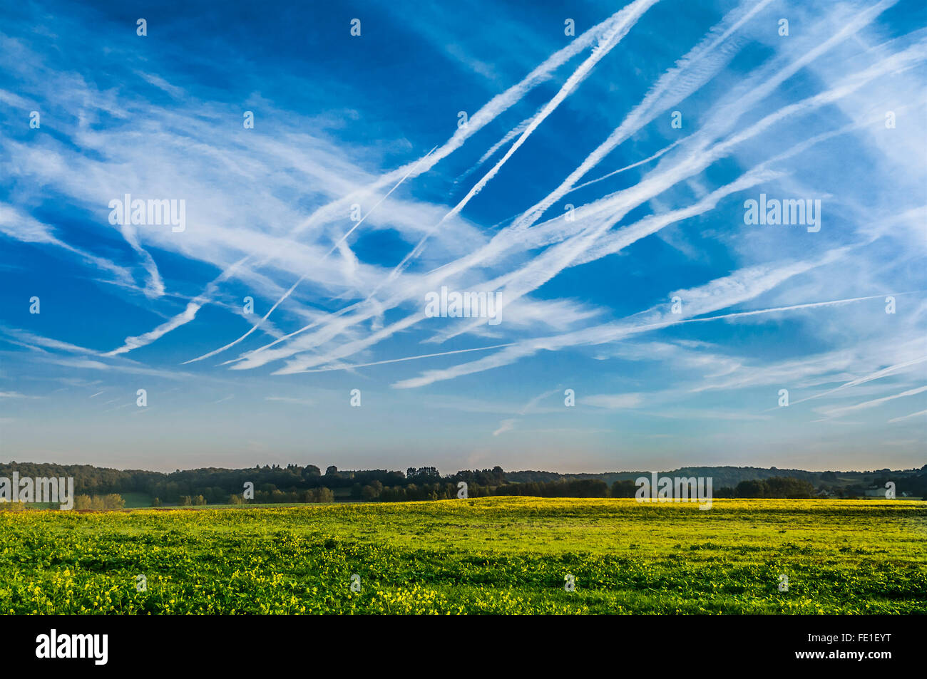 Blue skyscape with contrails or chemtrails - France. Stock Photo