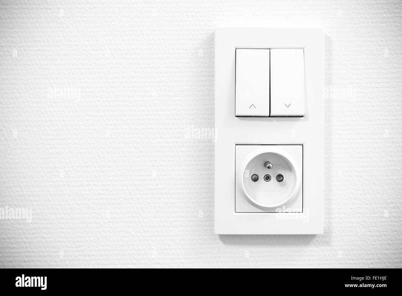 light switch and socket in frame on the wall Stock Photo