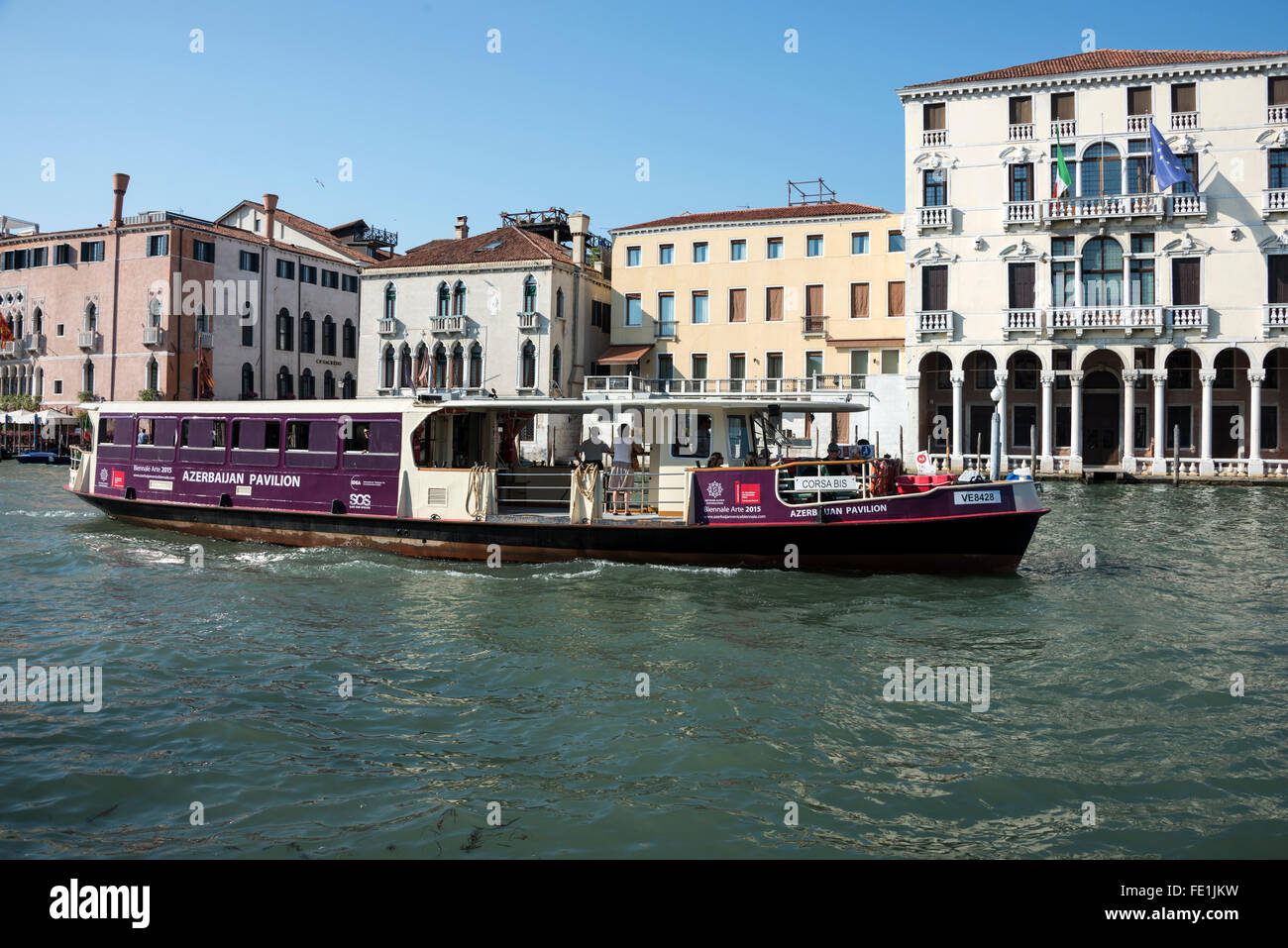 An ACTV water bus (Vaporetto) operating on the Canal Grande (Grand Canal) passing the white building with an arch frontage of the famous 5-star Anan Stock Photo
