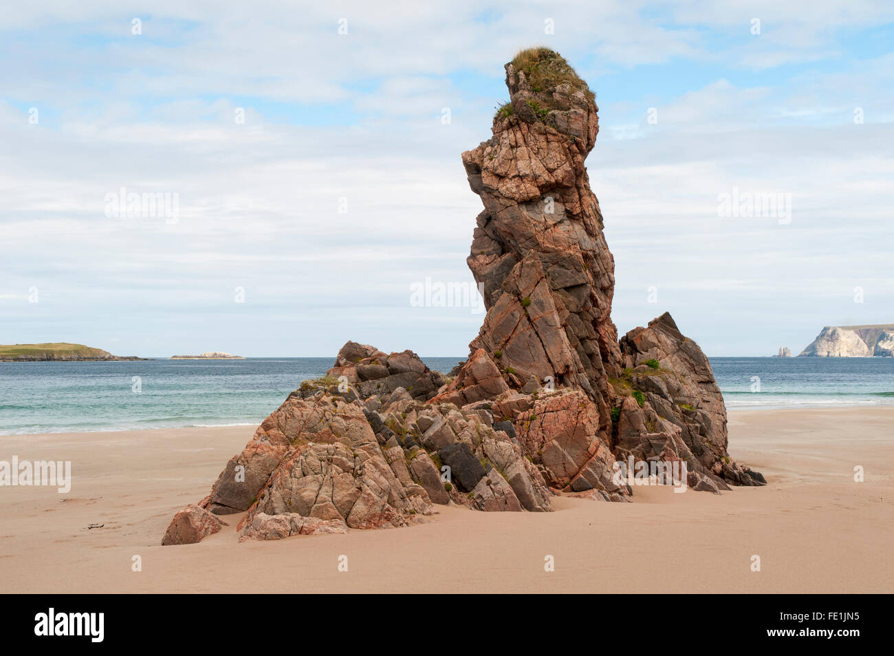An outcrop of pink Lewisian gneiss rocks protruding from the beach of Traigh na h-Uamhag at Ceannabienne, near Durness, Sutherla Stock Photo