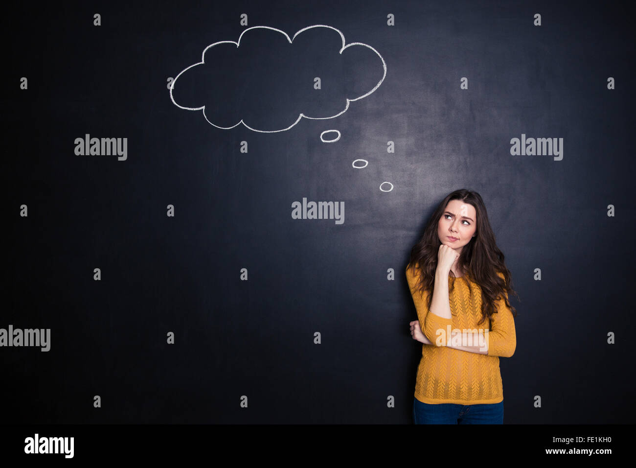 Portrait of a pensive woman standing over black background Stock Photo