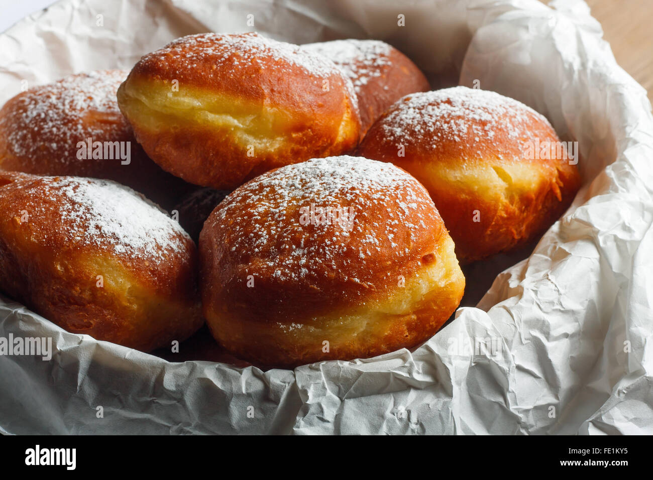 Homemade doughnuts filled with rose marmalade on wooden table. Stock Photo