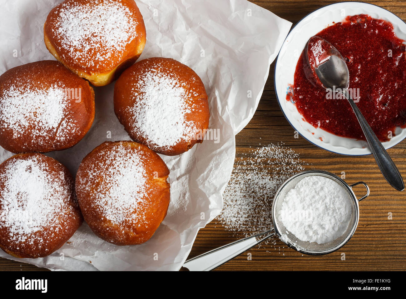 Homemade doughnuts filled with rose marmalade on wooden table. Stock Photo