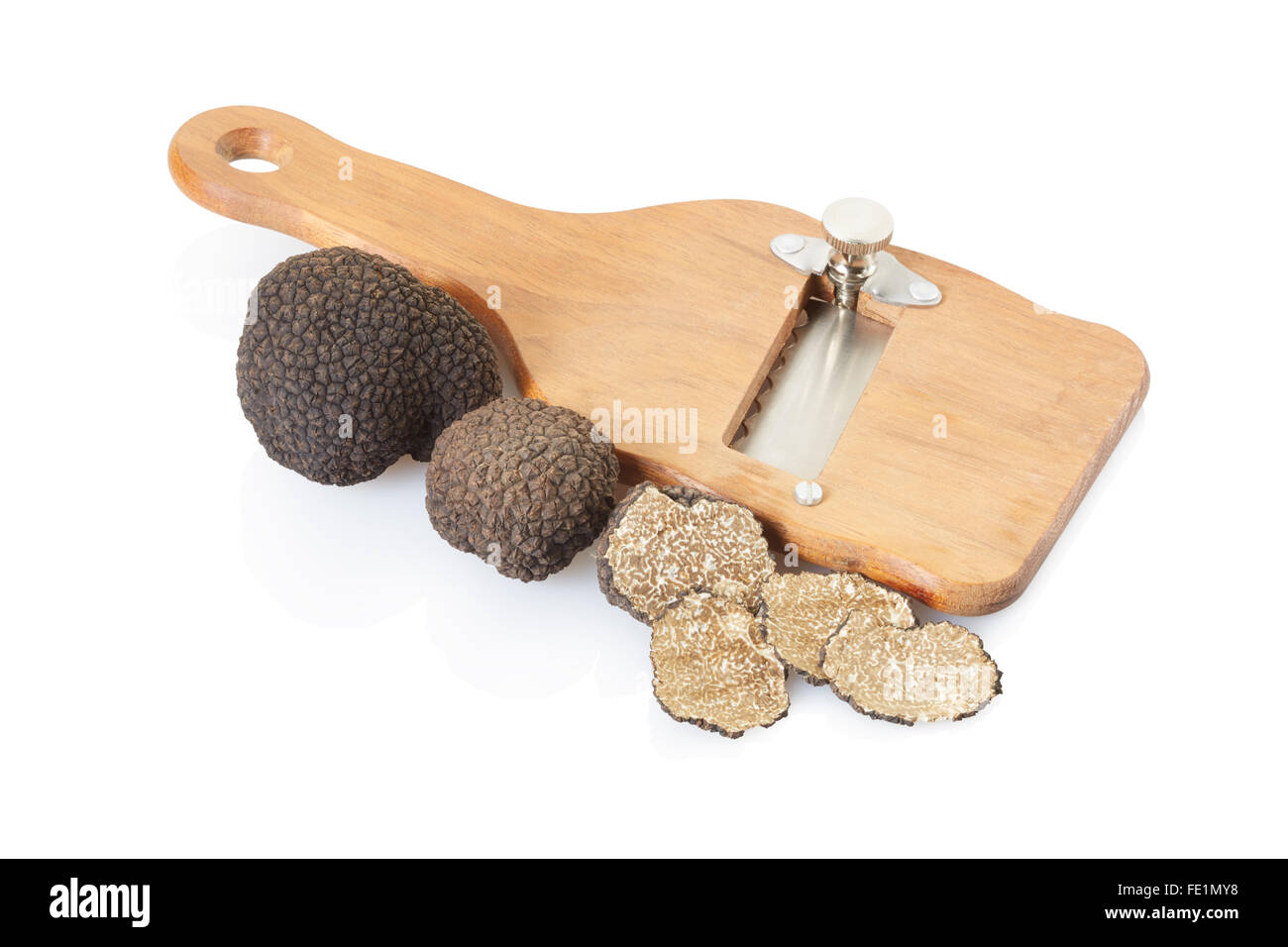Black truffle, slices and wooden truffle slicer on white Stock Photo