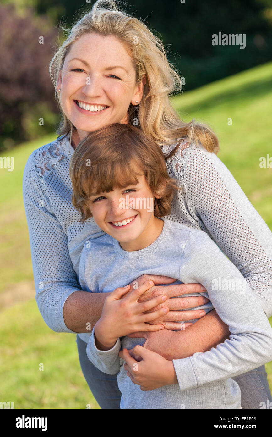 Mother and son, boy child and woman, playing & laughing together outside in summer sunshine Stock Photo
