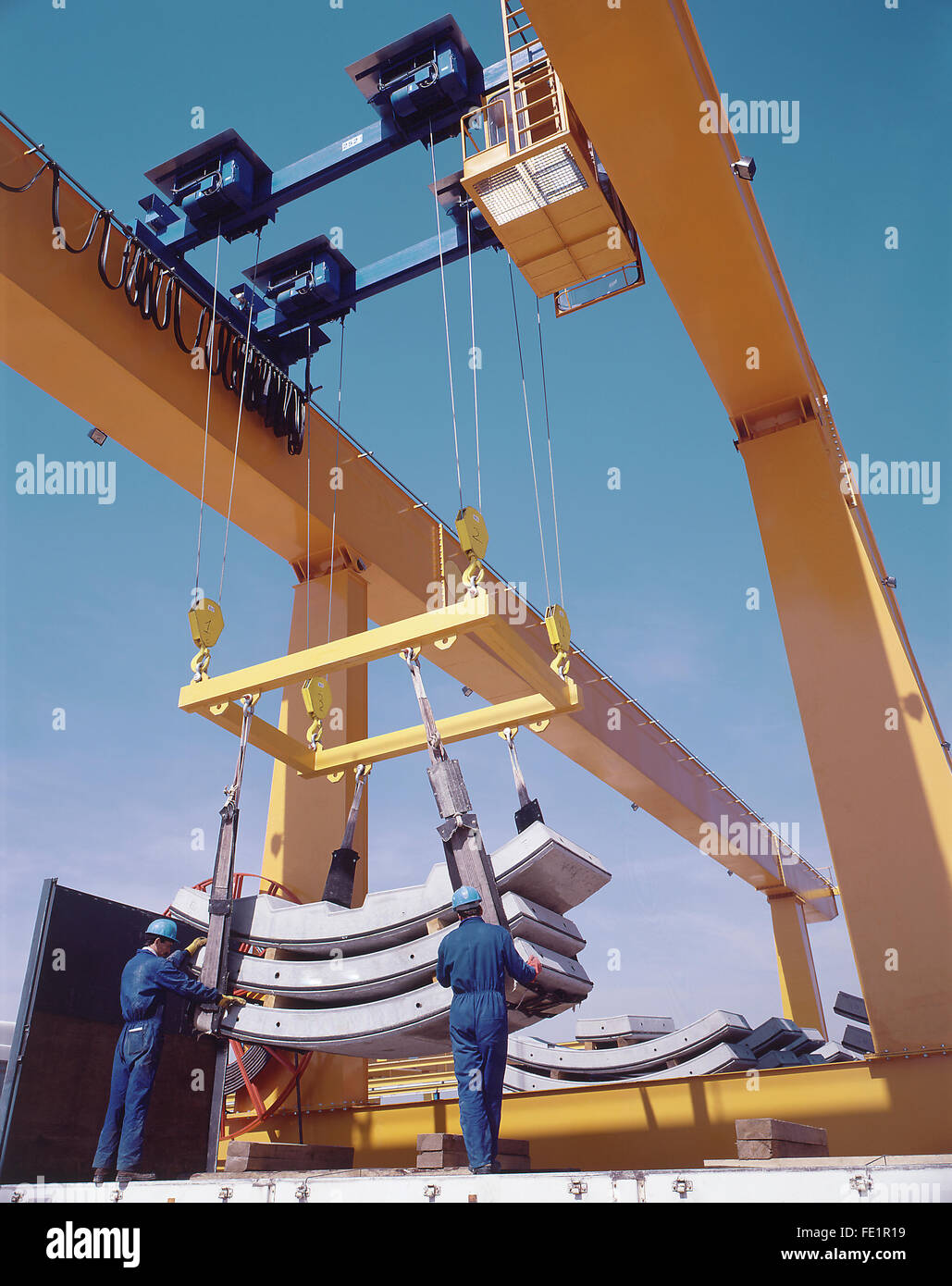 Overhead travelling crane with workers and precast segments. Vertical