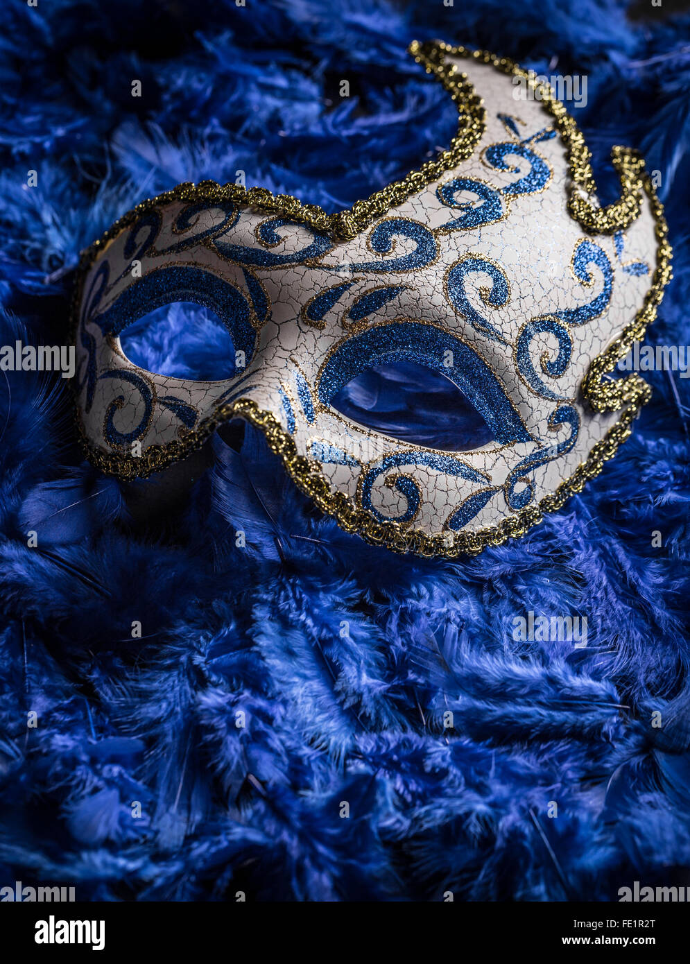 Female carnival mask on blue feather background Stock Photo