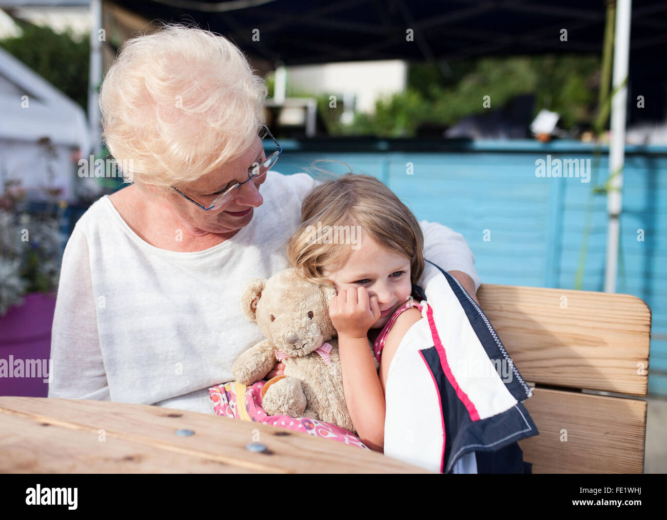 Grandmother cuddling granddaughter Stock Photo