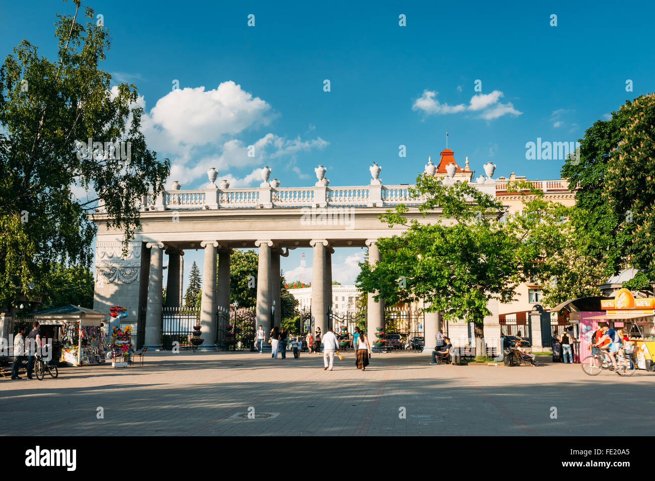 Main pillared entrance into Gorky Park in Minsk, Belarus. People walking to Gorky park at summer evening Stock Photo