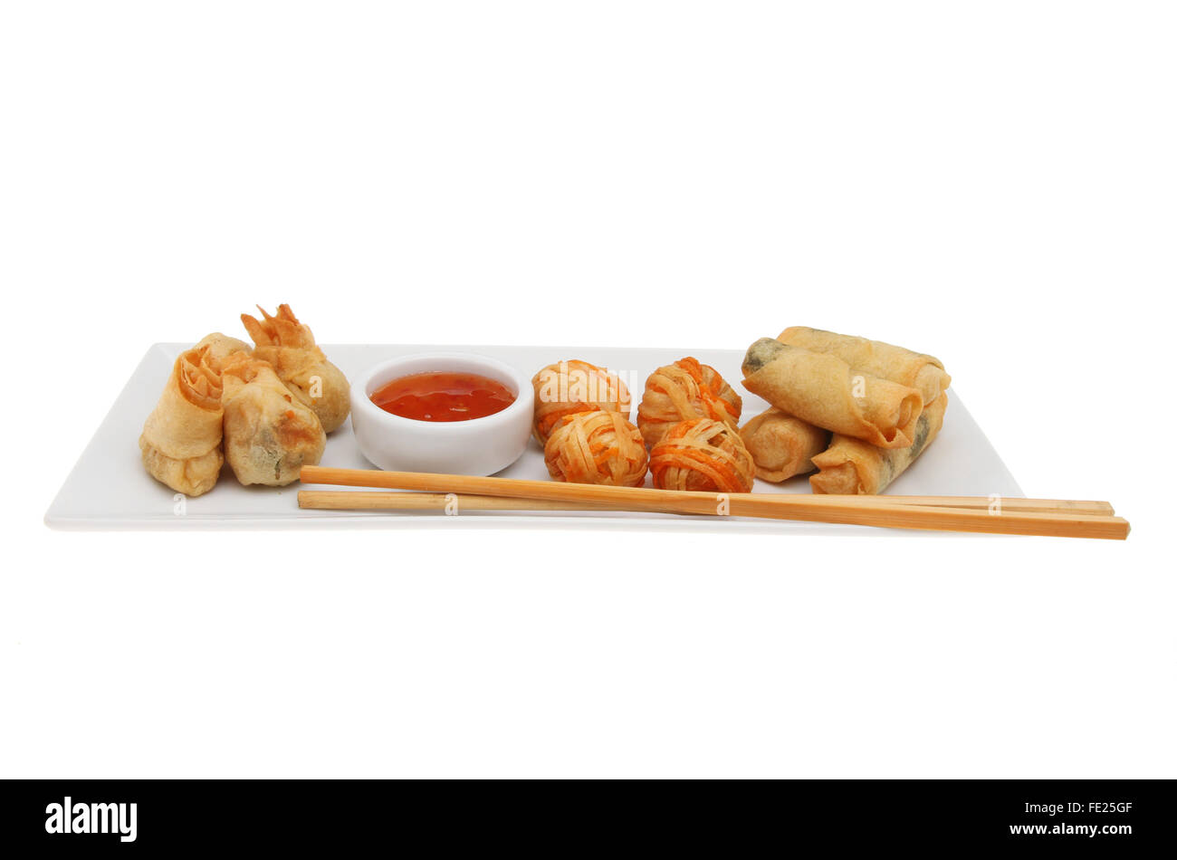 Oriental prawn and vegetable selection on a plate with dipping sauce and chopsticks isolated against white Stock Photo