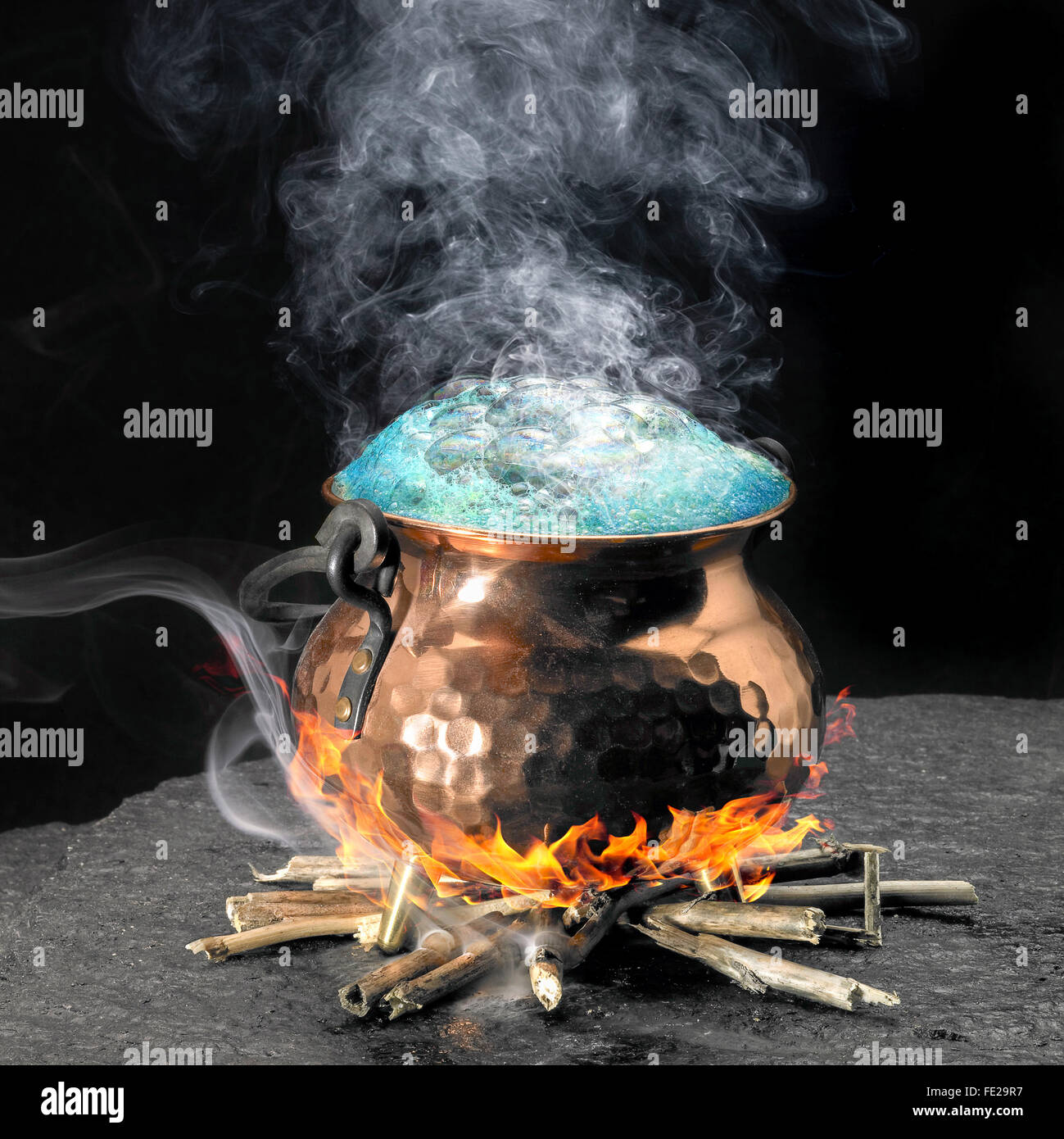 spumous potion and copper cauldron on a fireplace Stock Photo