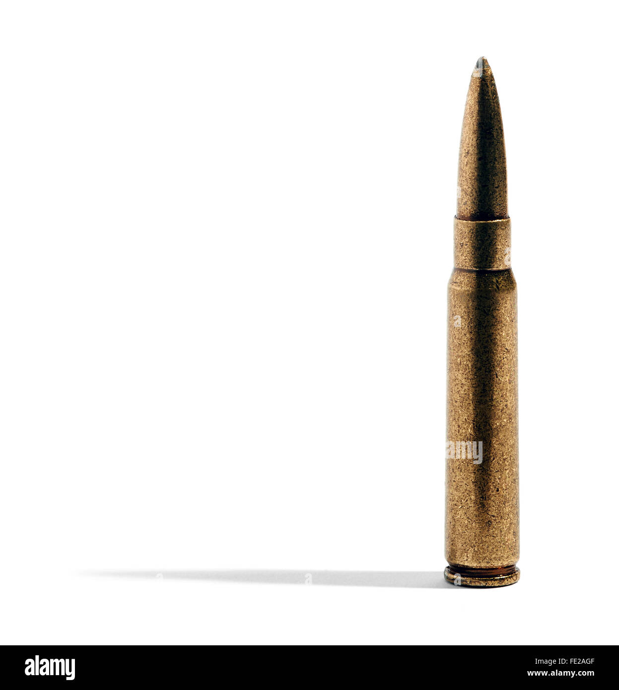 Close up on a single rifle bullet in a brass casing casting a lateral shadow over a white background with copy space Stock Photo