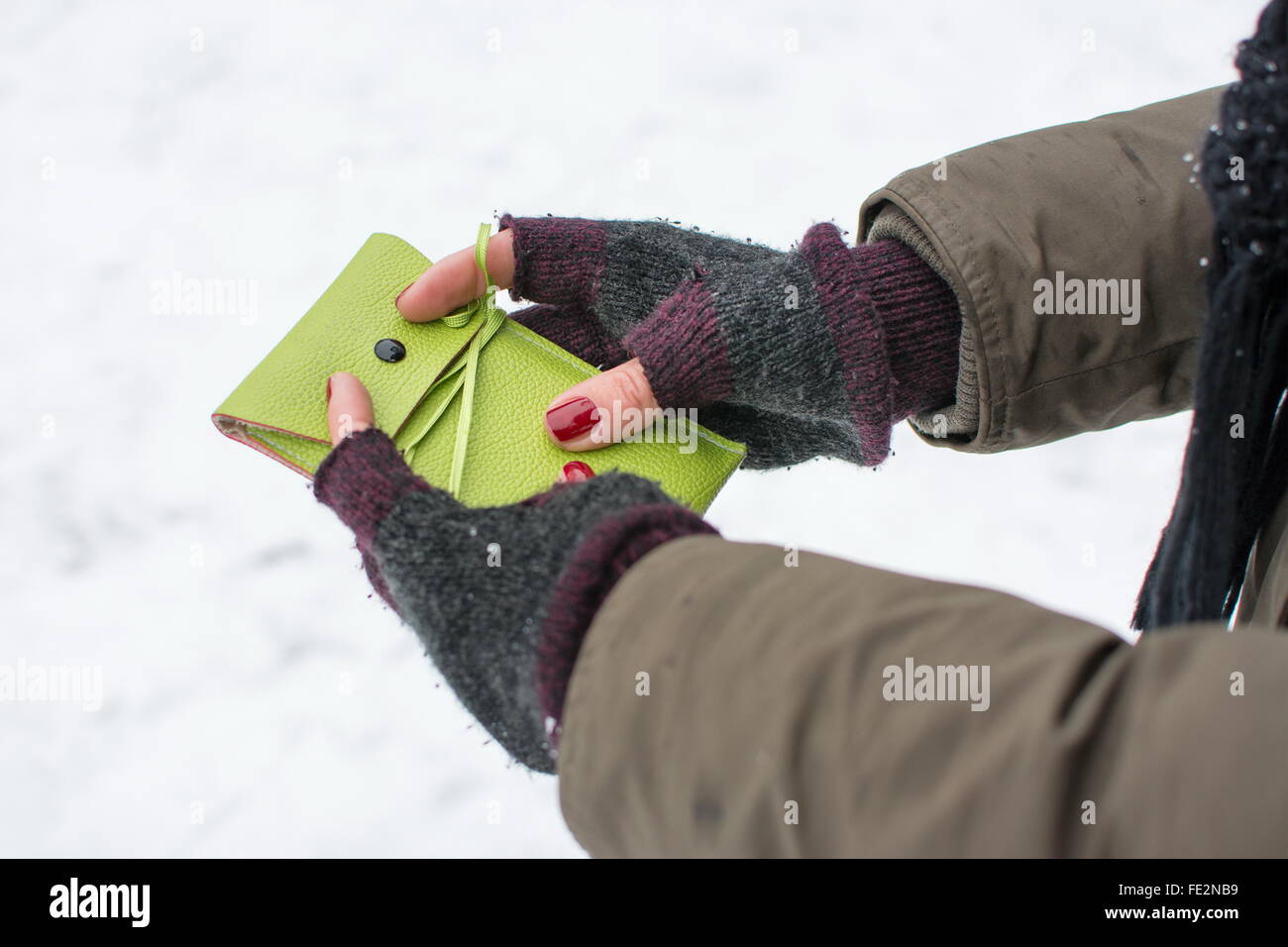 female holding green cellphone case outdoors in the winter Stock Photo